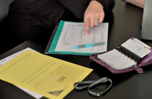 Formulare und Agenda mit Hand und Schreiber